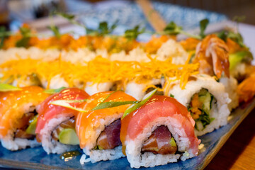 The variety of food showing the taste of Japan - mixed set of colorful seafood sushi, tuna, losos and shrimp nigiri, tempura and shrimp rolls