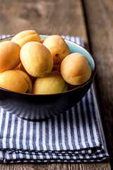 Raw Organic Apricots in a Bowl Linen Napkin Old Wooden Background Vertical