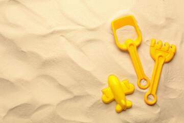 Fototapeta na wymiar Flat lay of beach toy kit on sand, space for text. Outdoor play