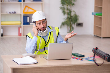 Young neck injured male architect in safety concept