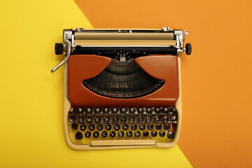 Vintage typewriter on color background, top view