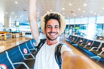 Happy tourist man taking a selfie portrait with mobile smart phone at airport - Airplane passenger...