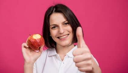 Beautiful young woman hold a big apple in her hand