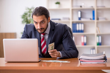 Naklejka premium Young male employee playing cards at workplace