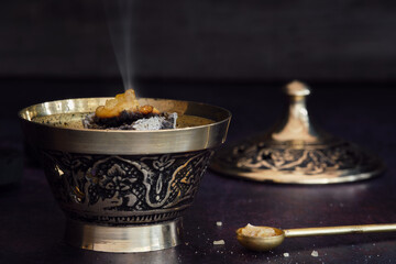 Fragrant frankincense resin (olibanum) on glowing charcoal in a censer