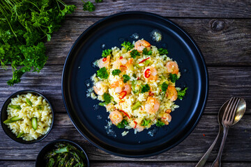 Risotto with shrimps and asparagus on wooden background
