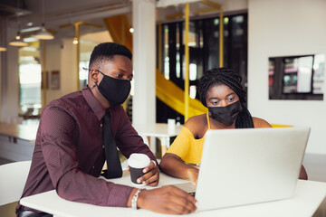 African students With friends Wearing Mask Sitting At Desk At modern school . Virus Protection At...