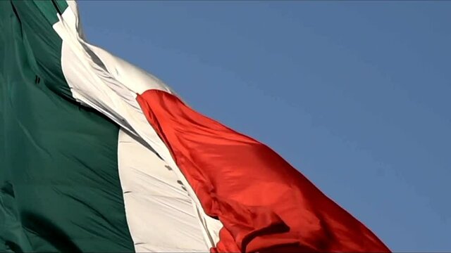 Mexican flag agitated in the wind,closeup,Mexican coat of arms in the foreground