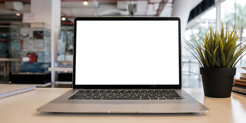 Blank screen Laptop computer and poster workspace background in modern office