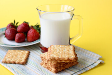 Milk and biscuits, a plate with strawberries. Healthy food concept.