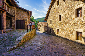 Stone houses and narrow alley in mountain village in northern Spain. Barcena Mayor.