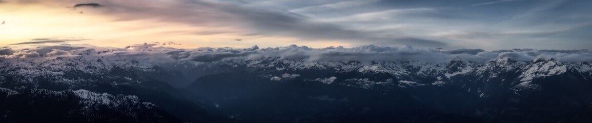 Aerial Panoramic View from Airplane of Canadian Mountain Landscape in Spring time. Colorful Sunset. North of Vancouver, British Columbia, Canada. Nature Panorama, Dark Moody Art Render