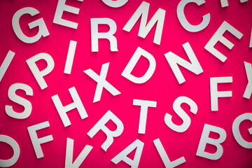 Mixed letters pile top view photo. Pink background