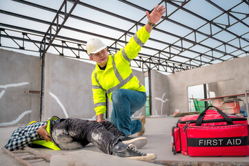 Accident at construction site. Physical injury at work of construction worker. First Aid Help a construction worker who accident at construction site. First Aid Help at accident in constructions work.