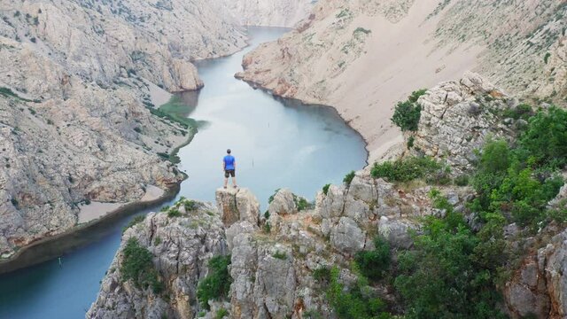 Man is standing on the cliff above the canyon of the Zrmanja River, Croatia