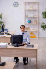 Fototapeta premium Young male employee sitting in the office