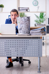 Young businessman employee rejecting new ideas with lots of pape