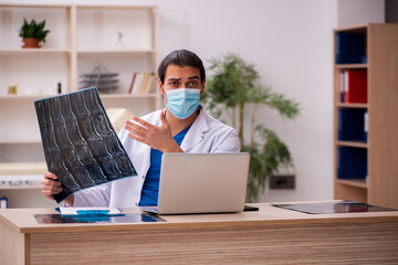 Young male doctor radiologist wearing face-mask during pandemic