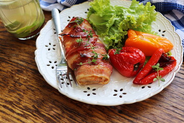 Grilled chicken breast wrapped in bacon served with salad on wooden rustic table . Dinner background