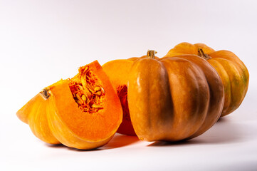 Whole fresh orange big pumpkin and slice of pumpkin on white background, closeup. Organic...