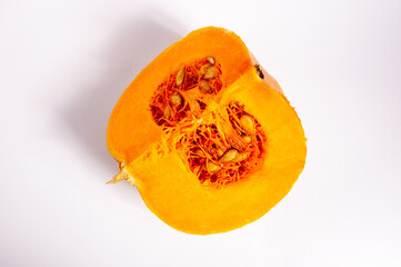 Cutted fresh orange big pumpkin on white background, close up. Organic agricultural product, ingredients for cooking, healthy food vegan.