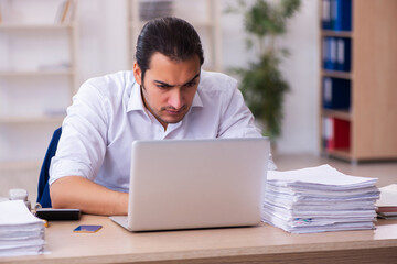 Young businessman employee unhappy with excessive work in the office