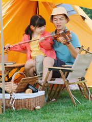 The young father taught his daughter to play the violin
