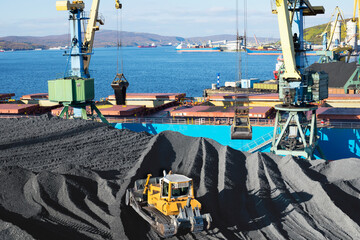 Coal is loaded into the holds of a dry cargo ship in the seaport 24 hours a day.