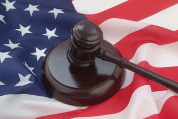 Wooden judge gavel on USA flag. Laws, court and legal system of US concept.
