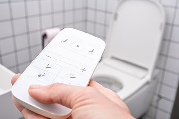 remote Control with buttons of the smart toilet bowl. high technology automatic modern flush toilet