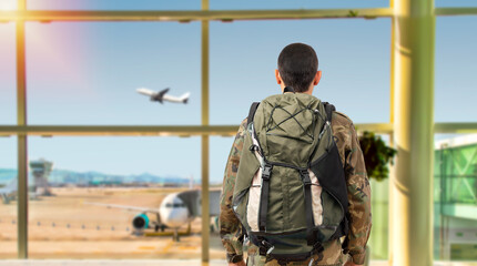 Shot of a soldier in a military uniform looking through the window at an airport