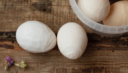 Deformed chicken egg on a wooden background. Ugly abnormal crooked egg.