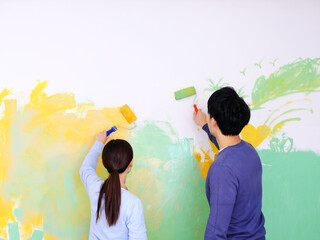 Photo of happy Young lovers painting wall