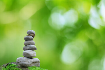 Obraz na płótnie Canvas Zen Stone Balance Spa Outdoor Beautiful Green Bokeh Background
