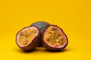 Cut in half Maracuja or Brazilian tropical passion fruit studio food still life against a yellow...