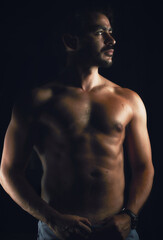 Fototapeta premium Man posing naked torso with black background
