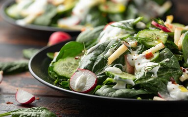 Fresh cucumber radish apple salad with spinach, dill and yogurt dressing. Healthy food