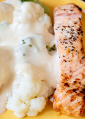 a keto diet friendly meal with salmon and cauliflower with cheese sauce 