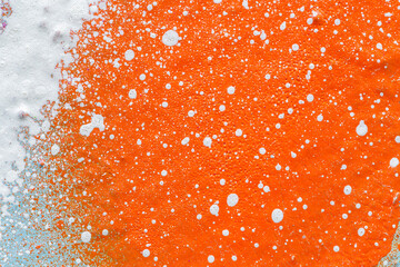 Macro close-up of a orange spray paint with white splashes. Abstract full frame textured splattered...