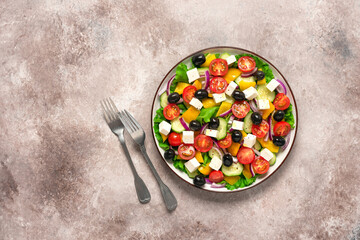 Greek salad on a brown grunge background. Top view, flat lay.