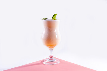 cold cocktail of fruit juice and indian drink lassi with mint on a pink background