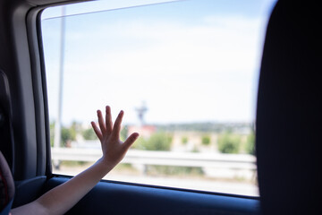 view of a kid looking through the window on a car trip