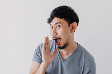 Funny Asian man is whispering some secret gossip isolated on white background.