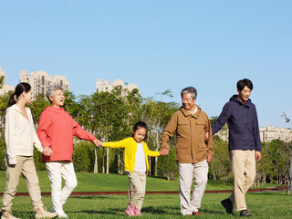 Obraz premium A happy family of five walking in the park