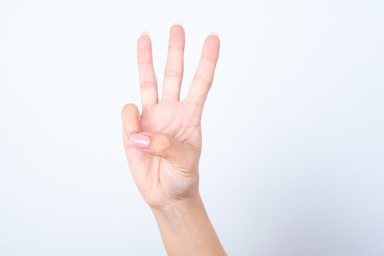 Woman's hand with pink manicure over isolated white background pointing up with fingers number three.
