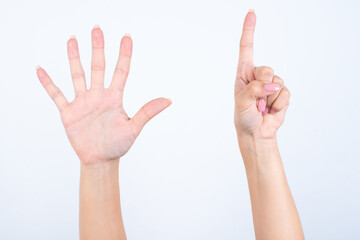 Woman's hands with pink manicure over isolated white background pointing with fingers number six.