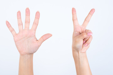 Woman's hands with pink manicure over isolated white background pointing with fingers number seven.