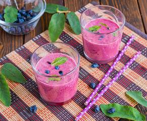 Smoothie or lassi, indian natural yogurt drink with honeysuckle in glasses on brown wooden...
