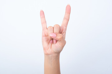 Isolated woman's hand gesturing up with hand rock and roll, horn sign. Front side view of the hand.