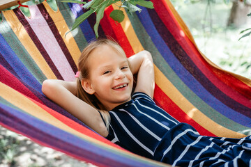 Cute girl in the colorful hammock summer background, summer holiday outdor activities